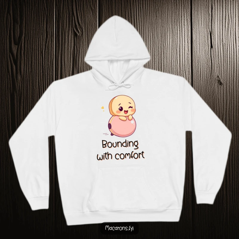 Soft hoodie featuring a funny macaron character winking while riding a bouncing ball with infectious glee.