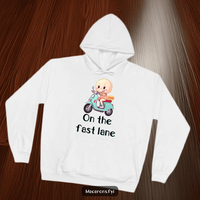Funny macaron character striking a triumphant pose on a scooter, zooming along, featured on a soft hoodie.