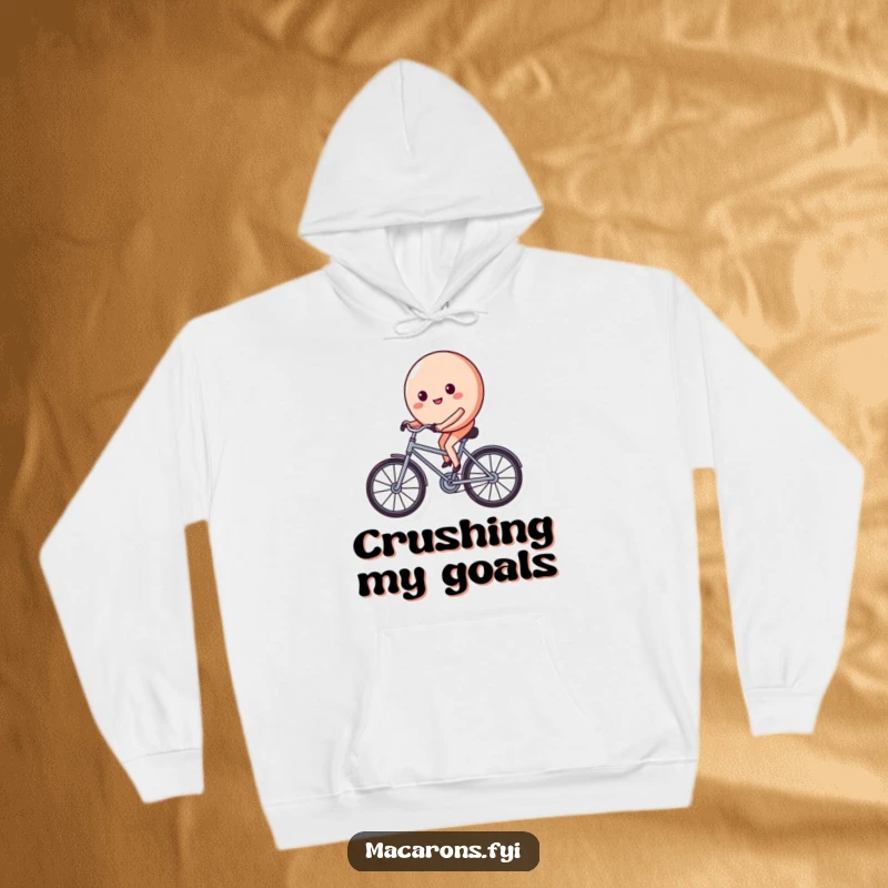 Funny macaron character on a tiny bicycle, pedaling with a determined and happy face, printed on a soft and warm hoodie.