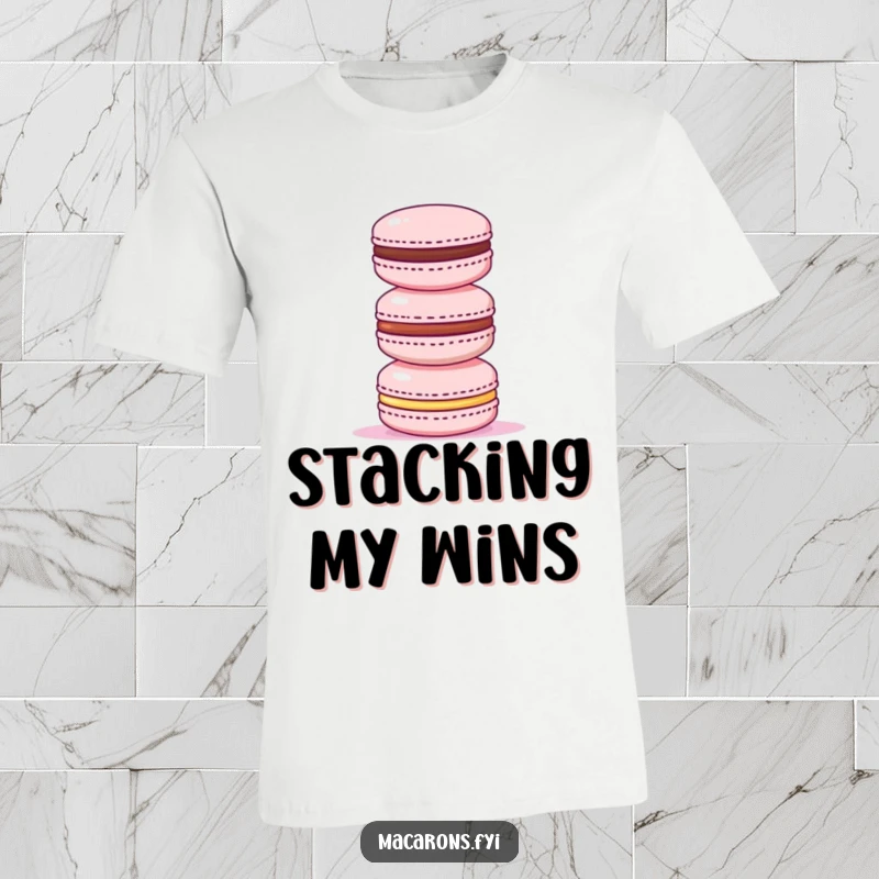 Funny t-shirt depicting a triumphant macaron at the pinnacle of a stack of smaller macarons, exuding success and sweetness.